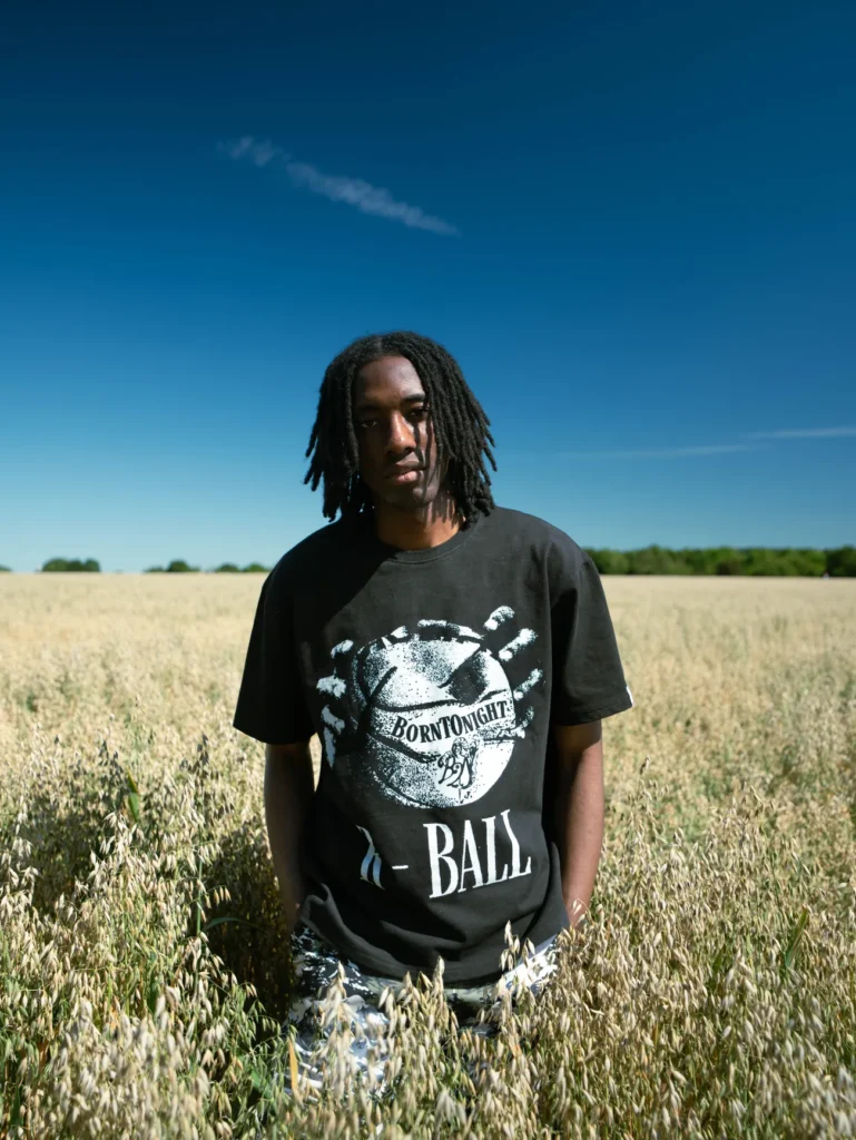 Homme en t-shirt R-BALL debout dans un champ d’avoine