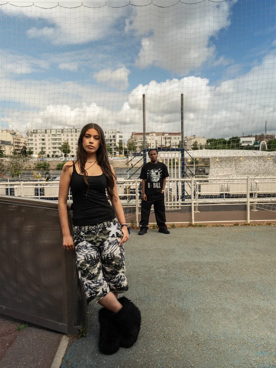 Femme au premier plan d’un terrain, homme en arrière-plan