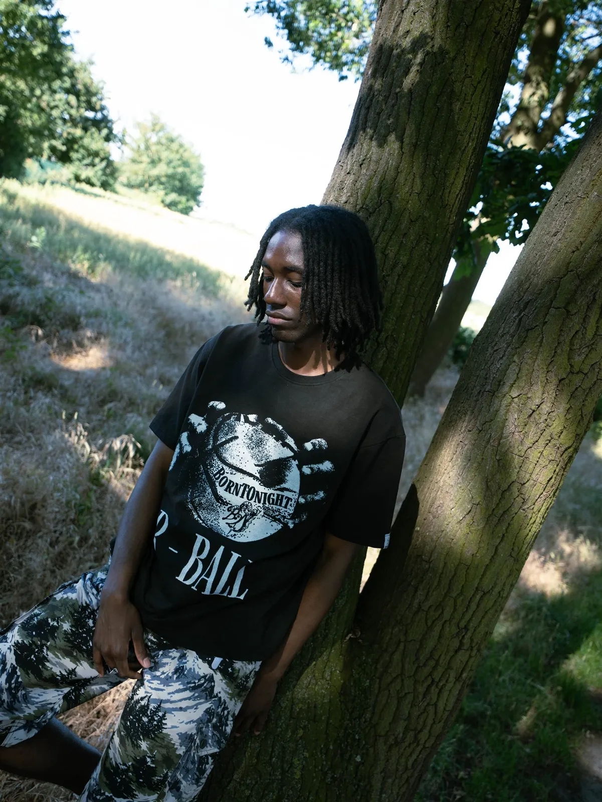 Homme adossé à un arbre, t-shirt R-BALL