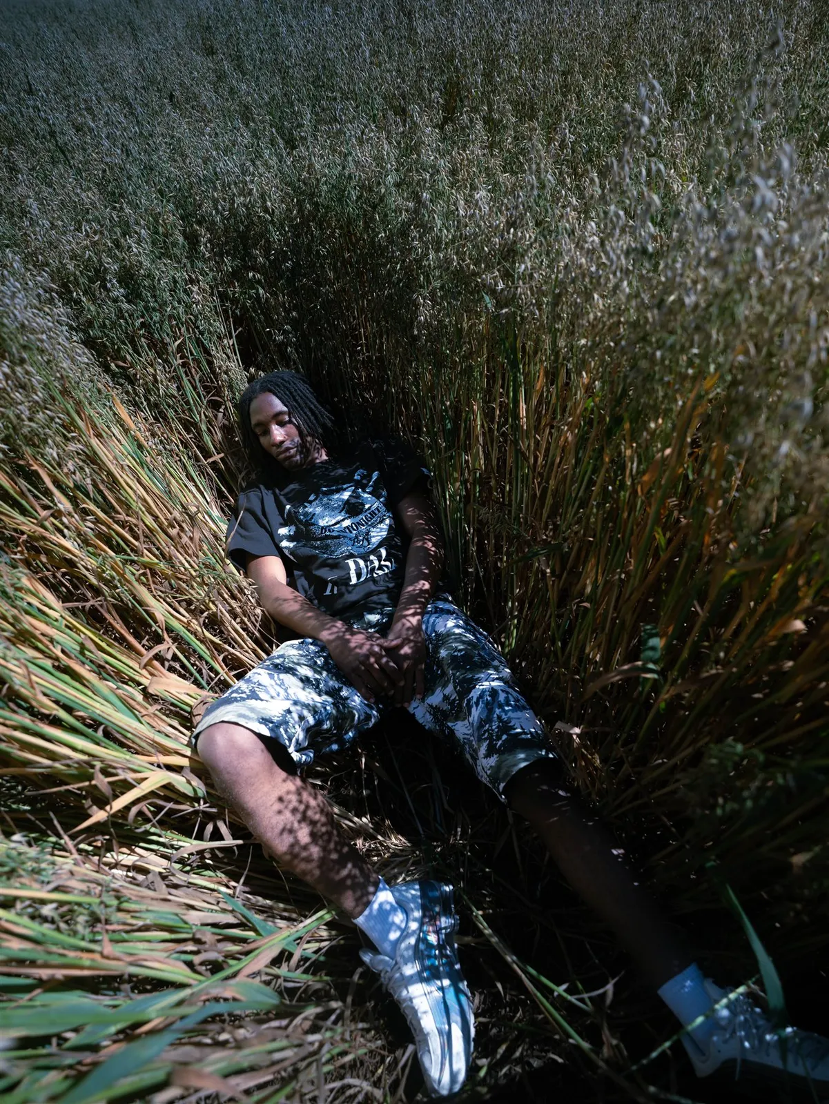Homme allongé dans les hautes herbes, short MOUNTAIN