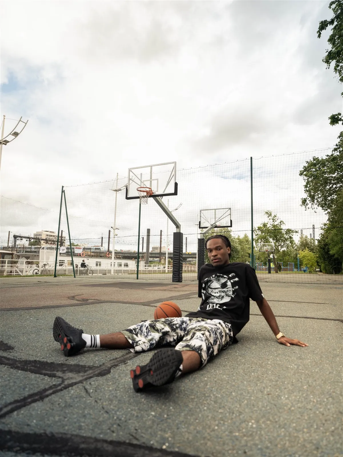 Homme assis au sol sur un terrain de basket